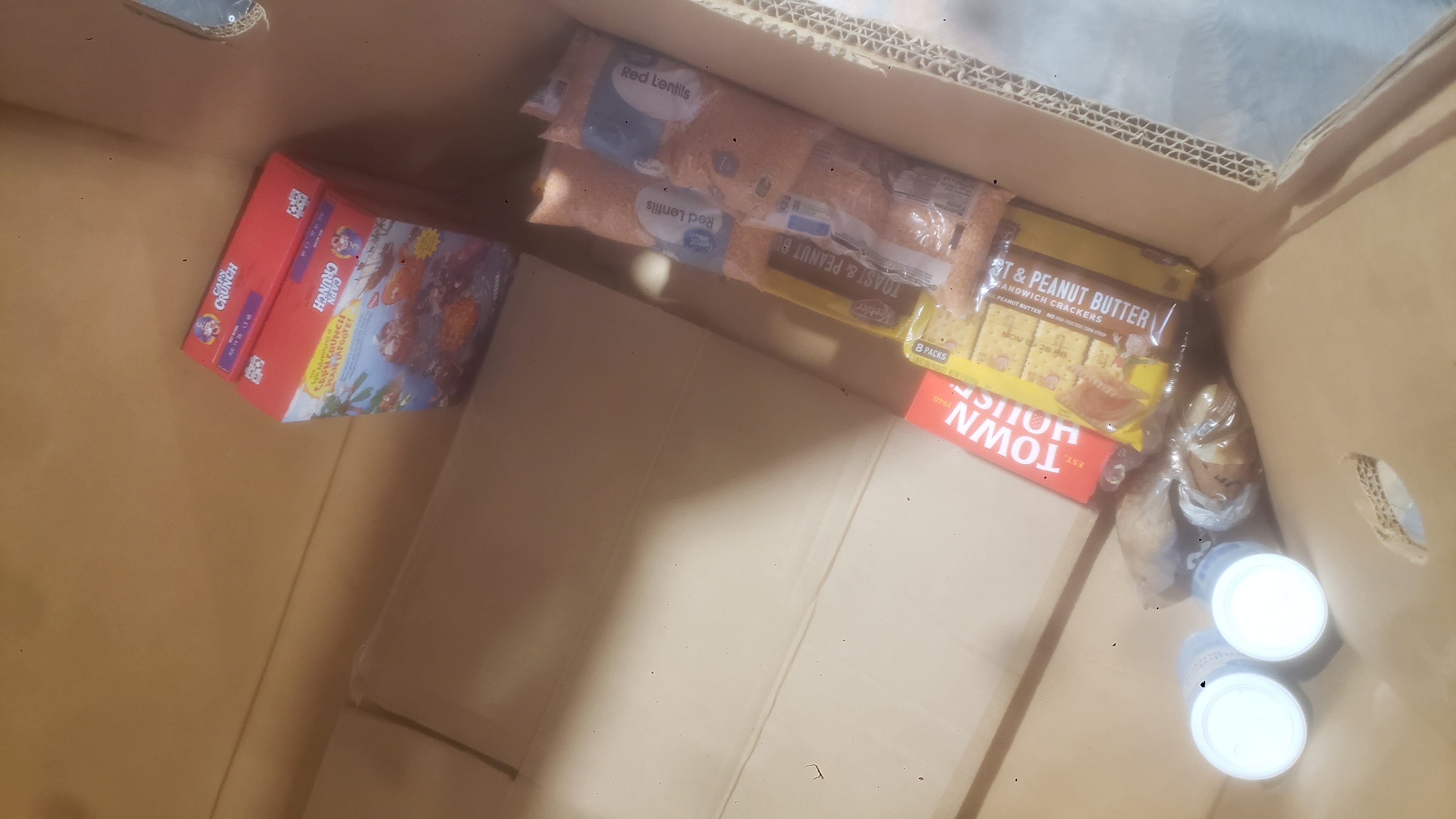 Cardboard container filled with a few items of food.
